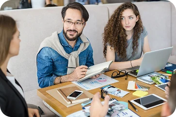 Two colleagues discussing work in a bright office