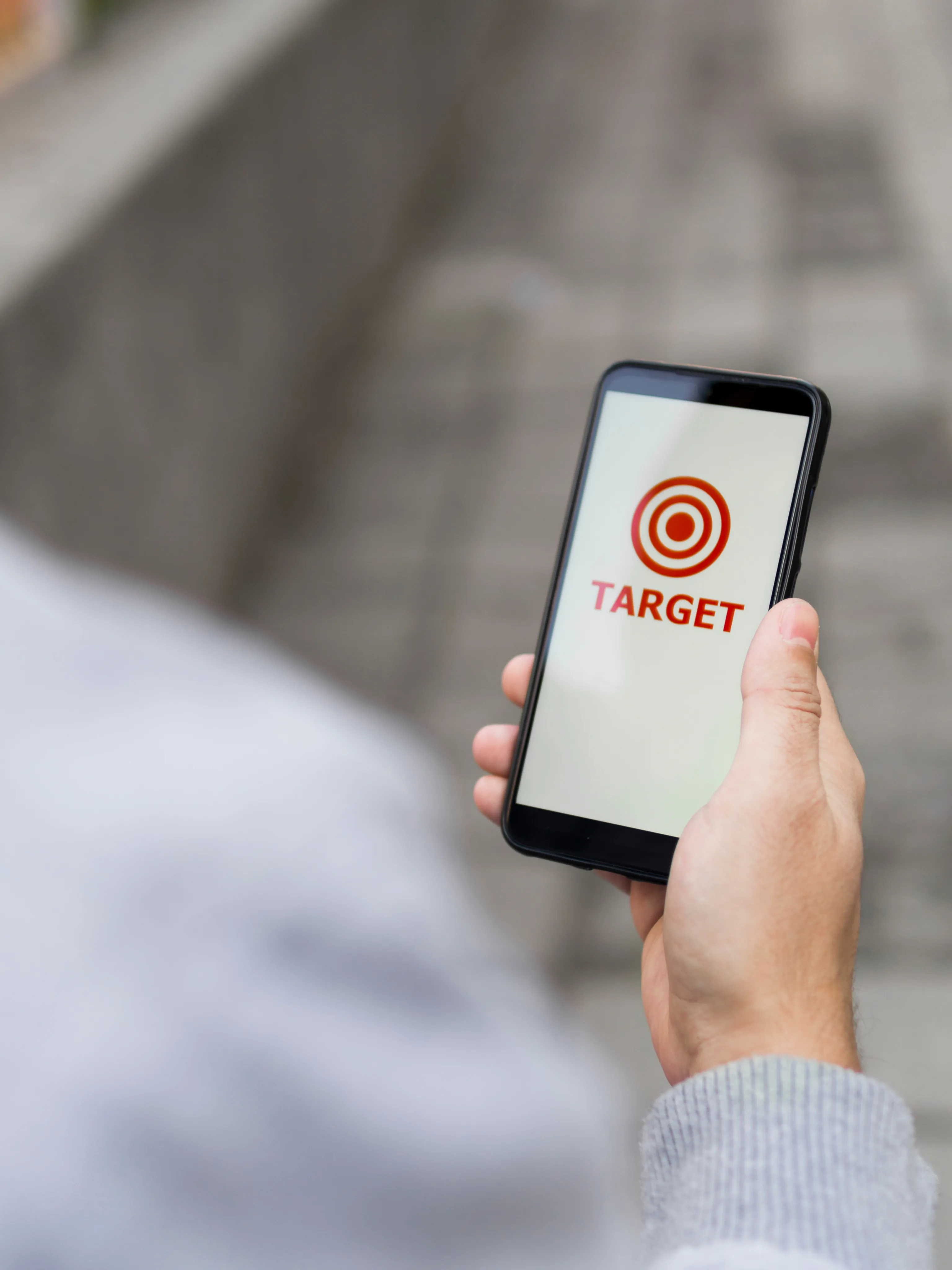 Hand holding a phone showing a target and focused campaign creative